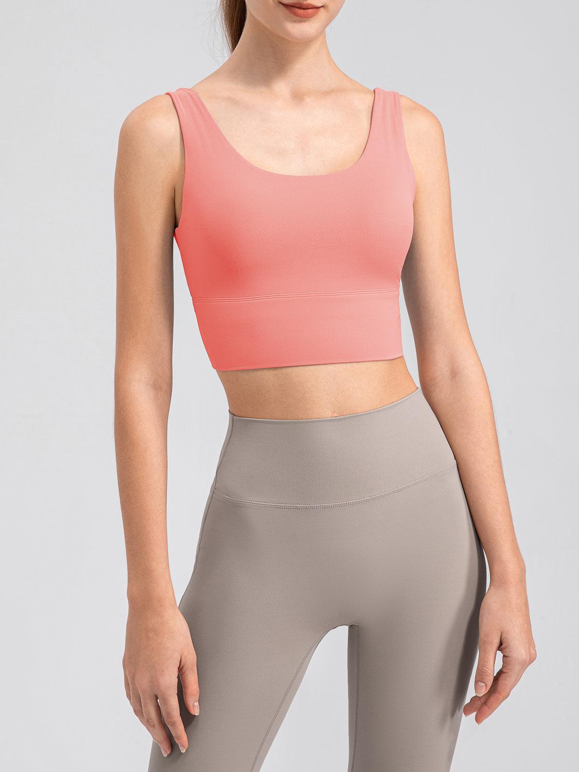 a woman in a pink top and grey leggings