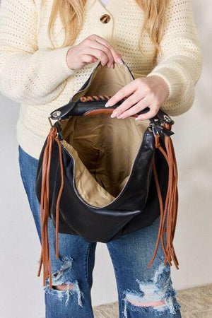 a woman holding a black purse in her hands