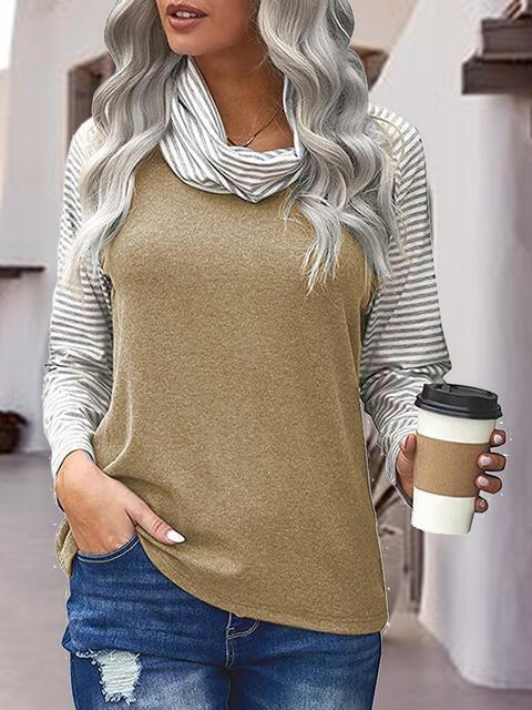 a woman holding a cup of coffee and wearing a sweater