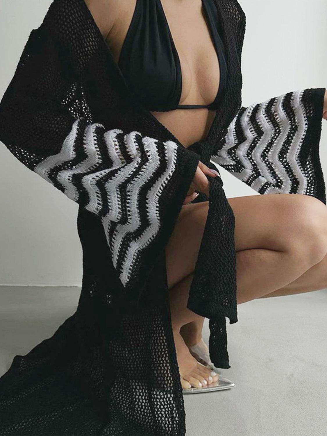 a woman in a black bikini top and black and white shawl