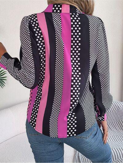 a woman wearing a black and pink shirt and jeans