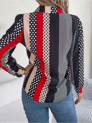 a woman wearing a polka dot blouse and jeans