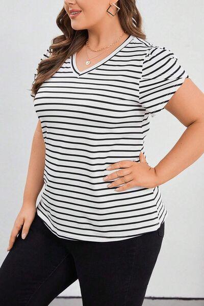 a woman in black and white striped shirt posing for a picture