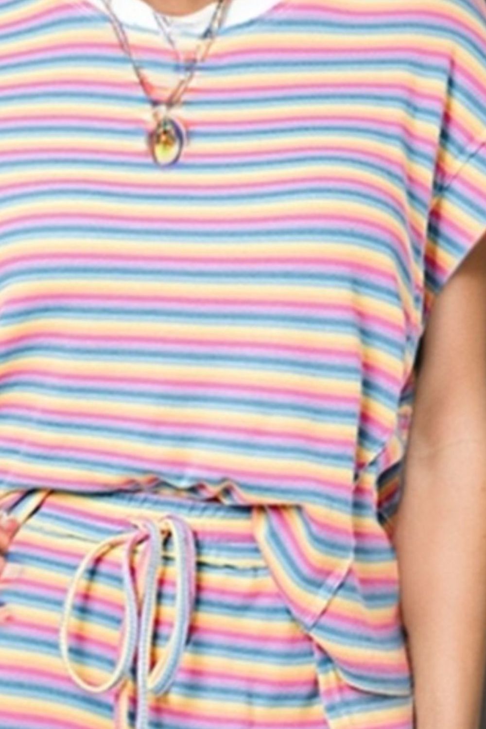 a woman wearing a colorful striped shirt and shorts