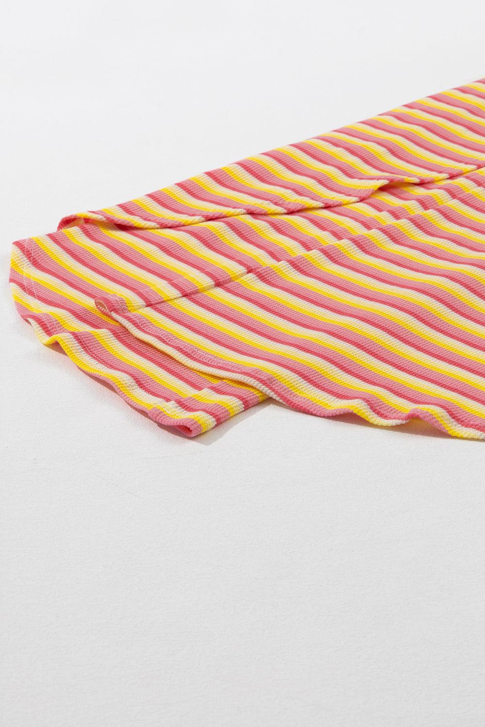 a pink and yellow stripped shirt laying on a white surface