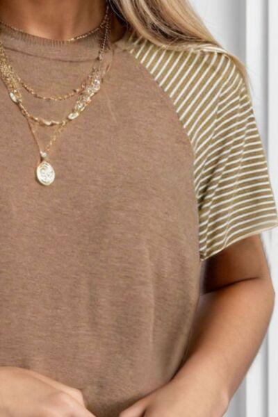 a woman wearing a brown shirt and a gold necklace