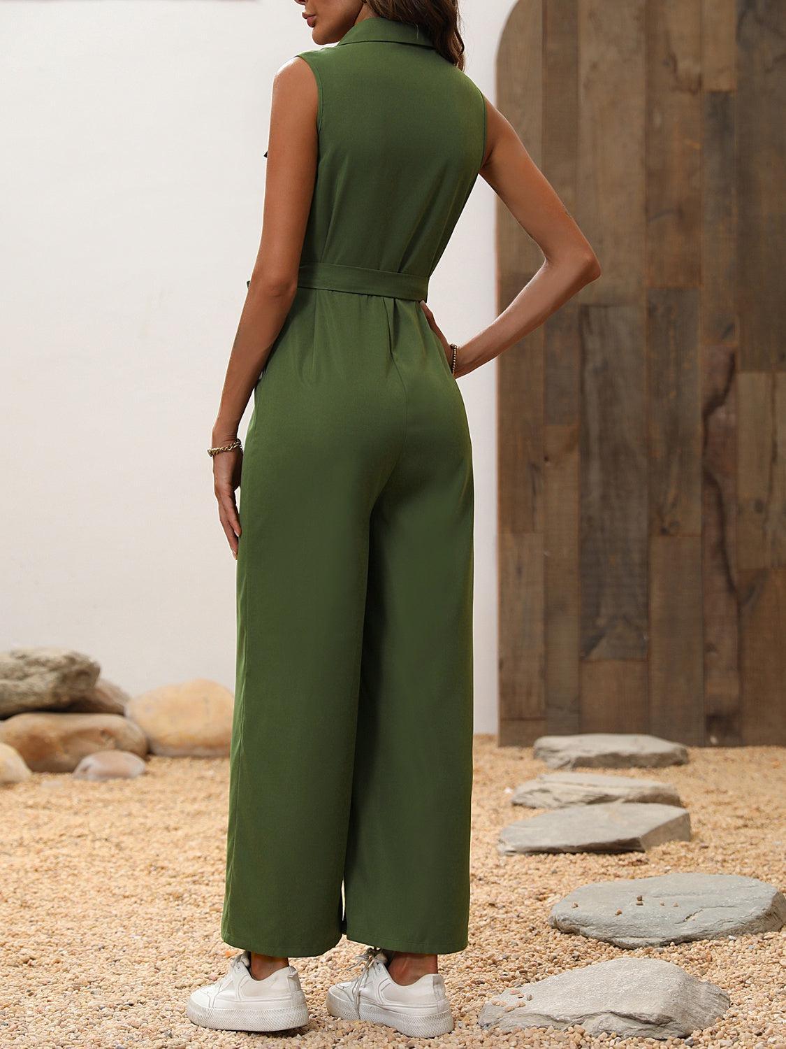 a woman in a green jumpsuit standing on rocks