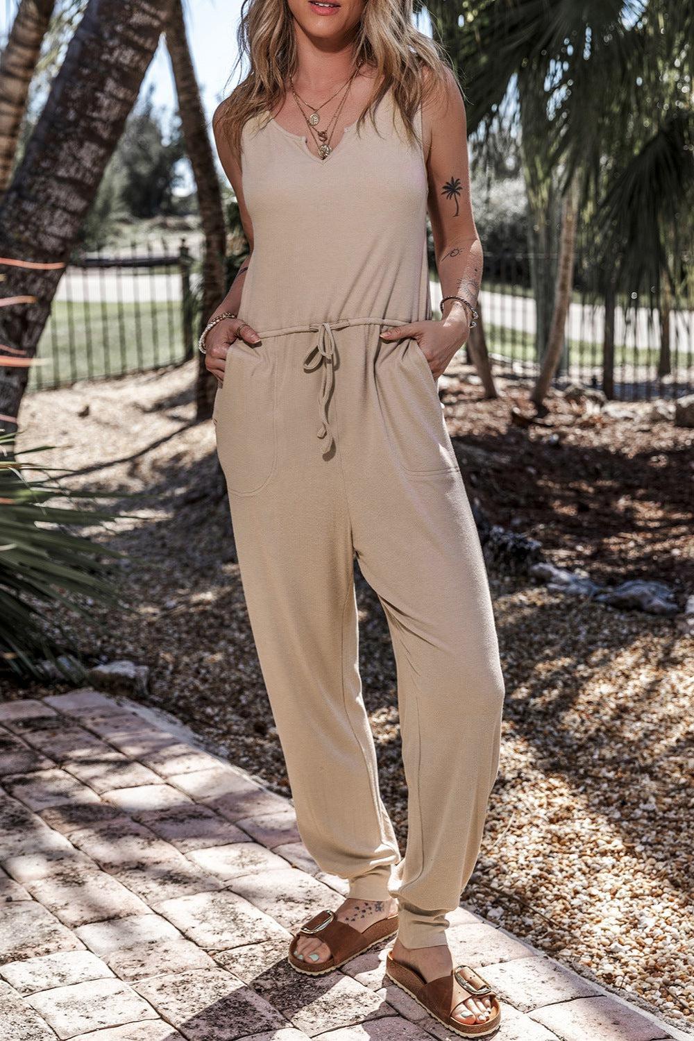 a woman in a tan jumpsuit posing for a picture