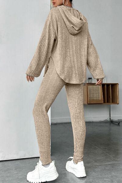 a woman in a sweater and pants standing in front of a wall