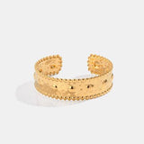 a gold cuff with beads on it