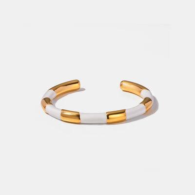a white and gold bracelet with two gold bars