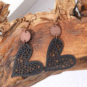 a pair of black and brown earrings on a piece of wood