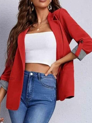 a woman wearing a red jacket and jeans