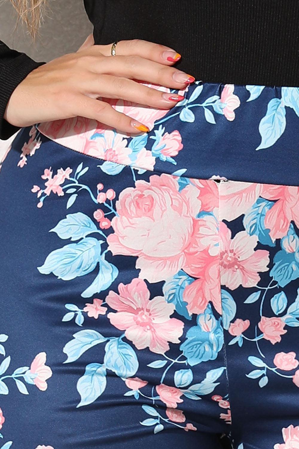 a close up of a person wearing floral pants