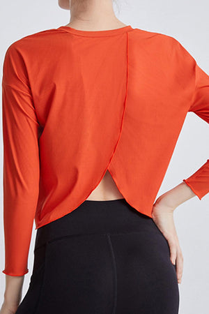 a woman wearing an orange top and black pants