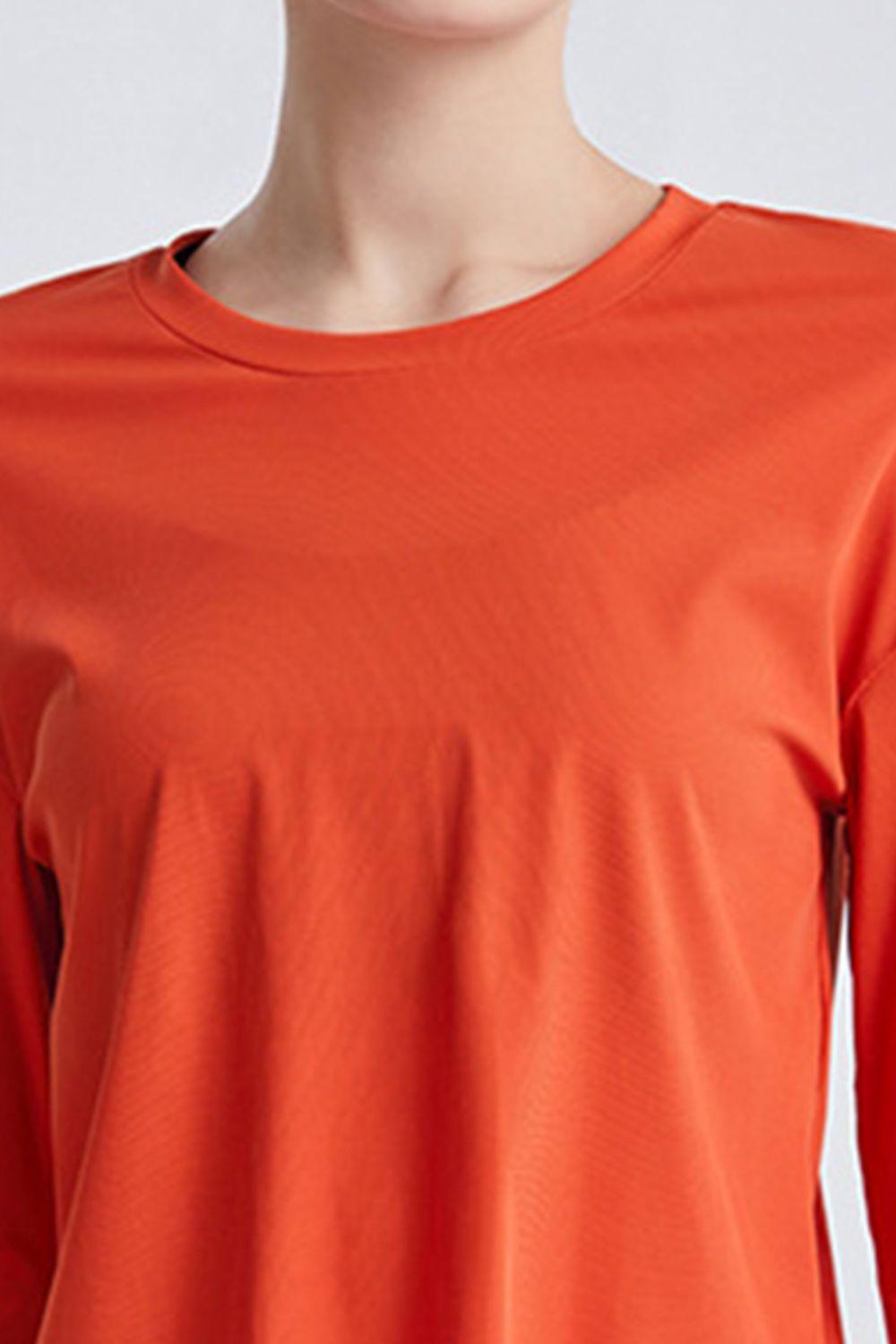 a woman wearing an orange shirt and black pants