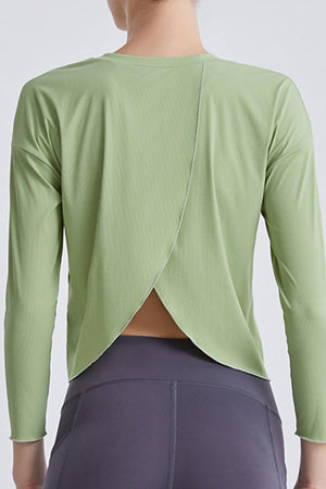 a woman wearing a green top with a back cut out