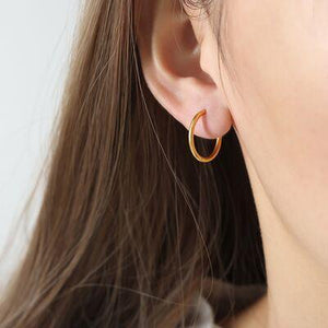 a close up of a person wearing a pair of earrings