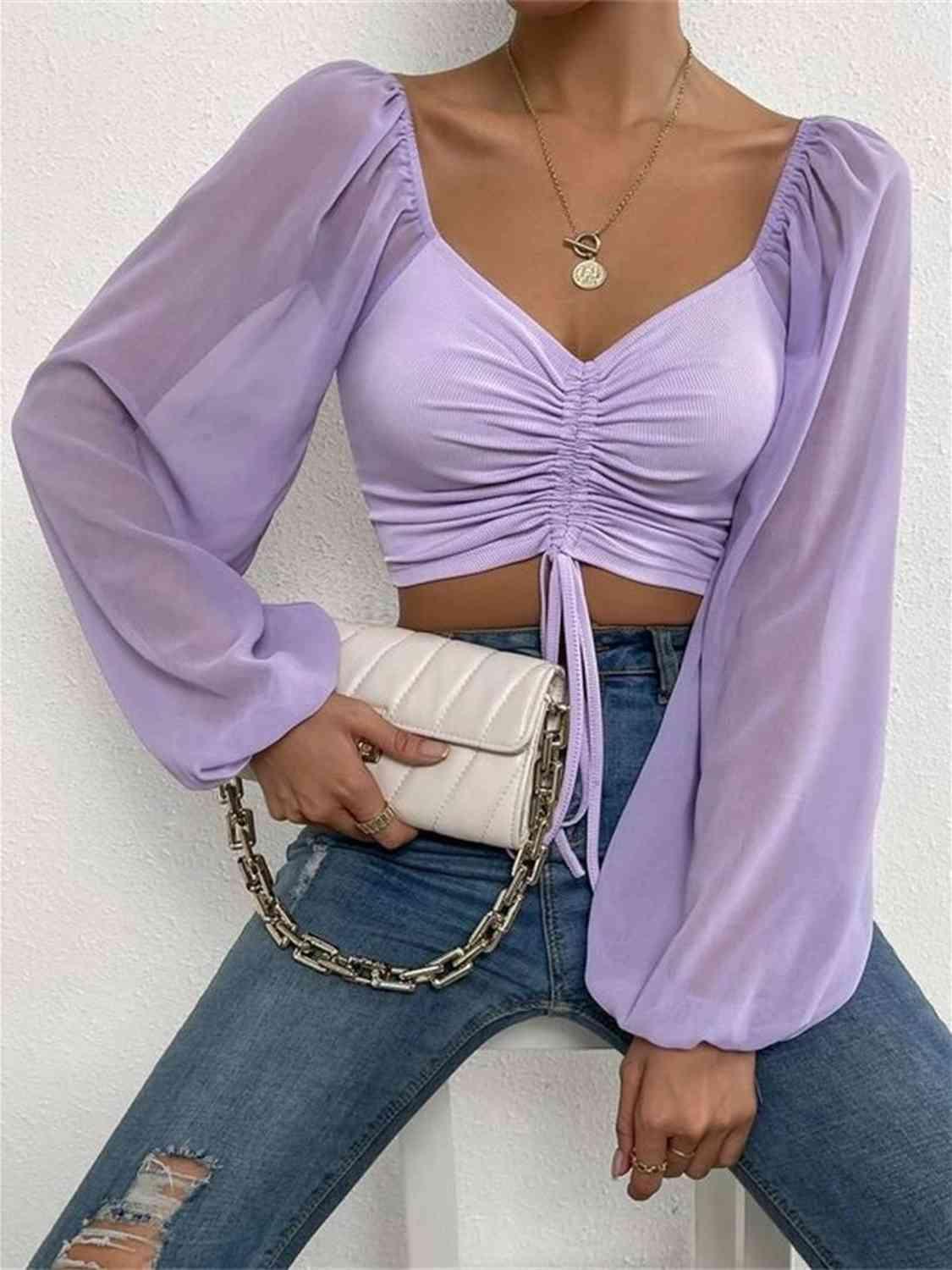 a woman wearing a purple top and jeans