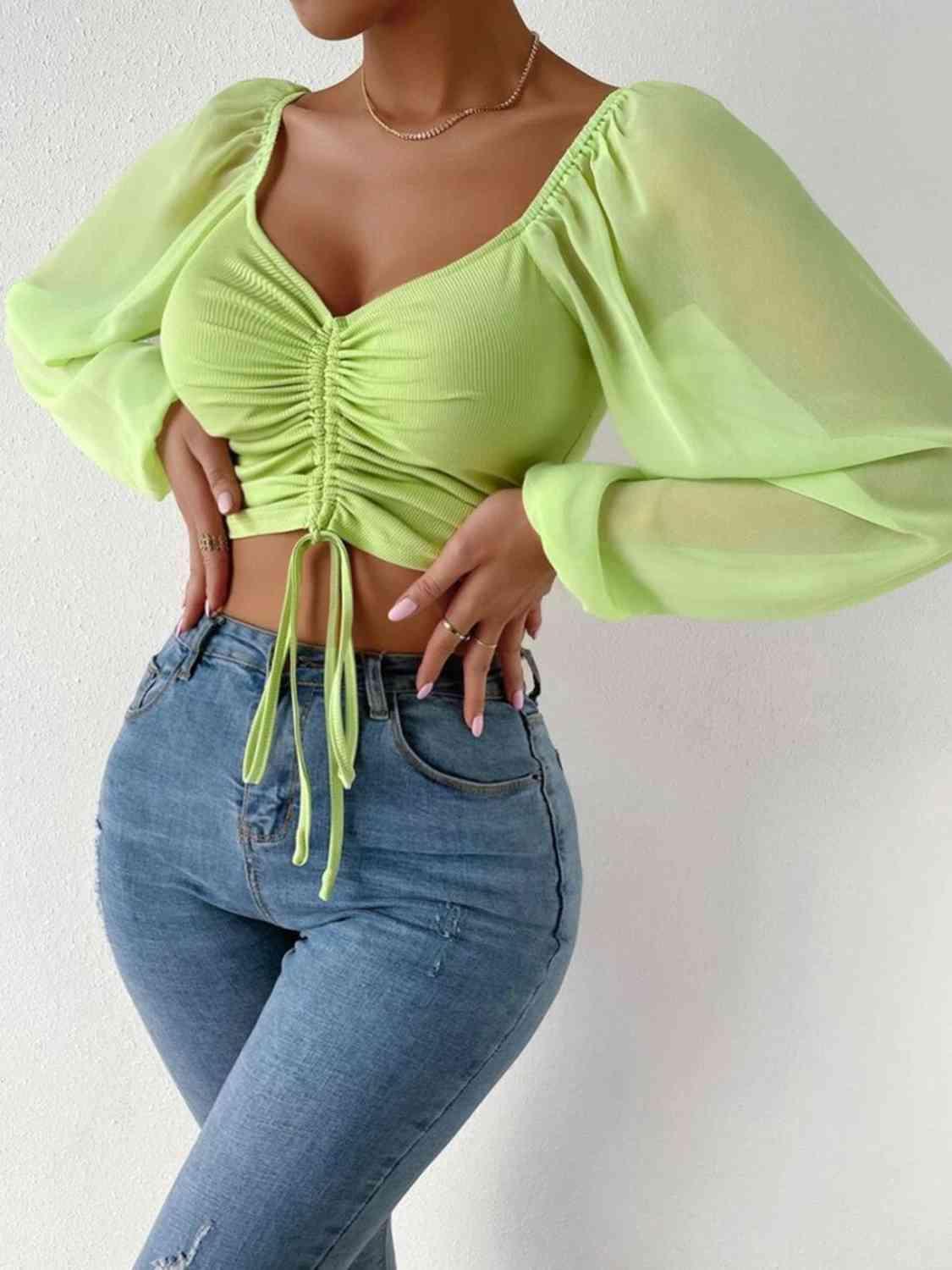 a woman wearing a green top and jeans