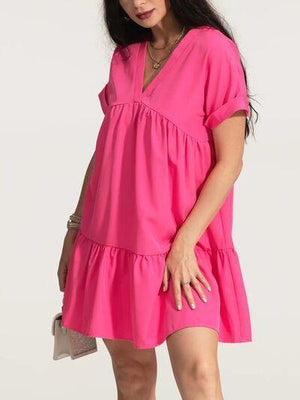 a woman in a pink dress posing for a picture