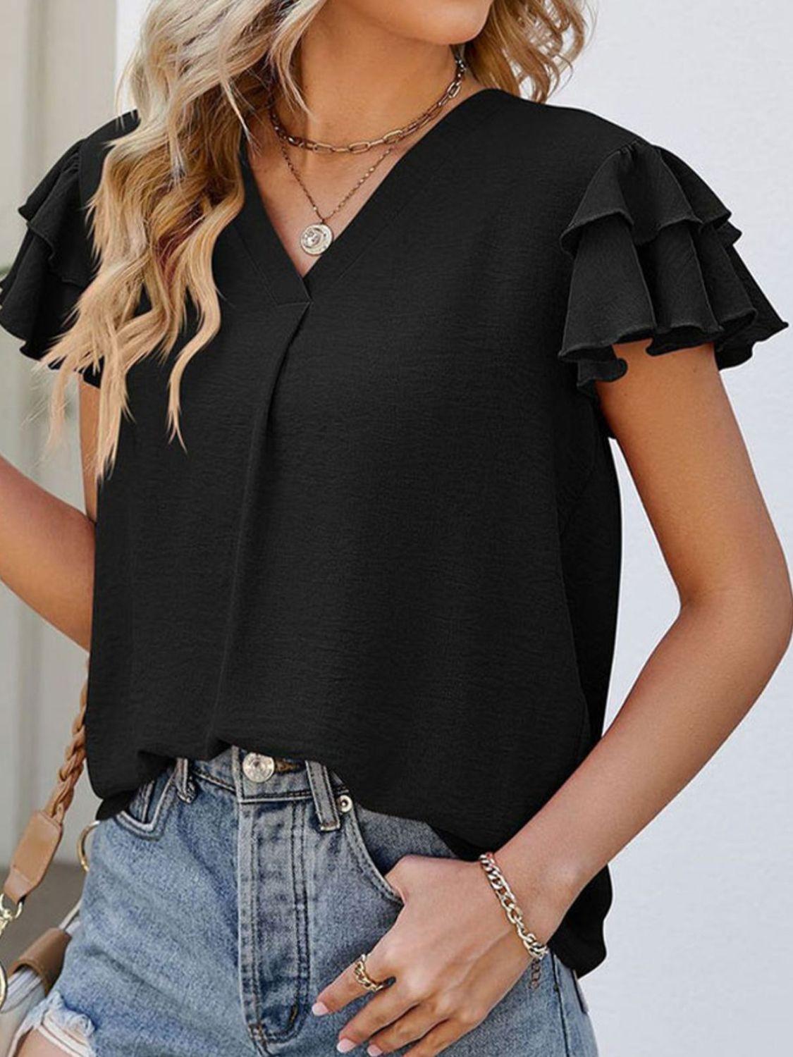 a woman wearing a black top with ruffled sleeves