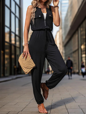 a woman wearing a black jumpsuit and a straw hat