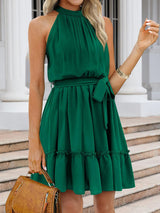 a woman in a green dress holding a brown purse