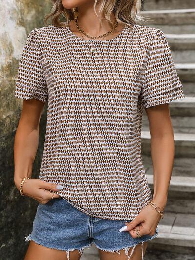 a woman wearing a brown and white patterned top