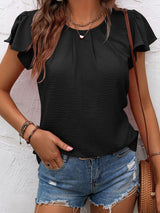 a woman wearing a black top and denim shorts