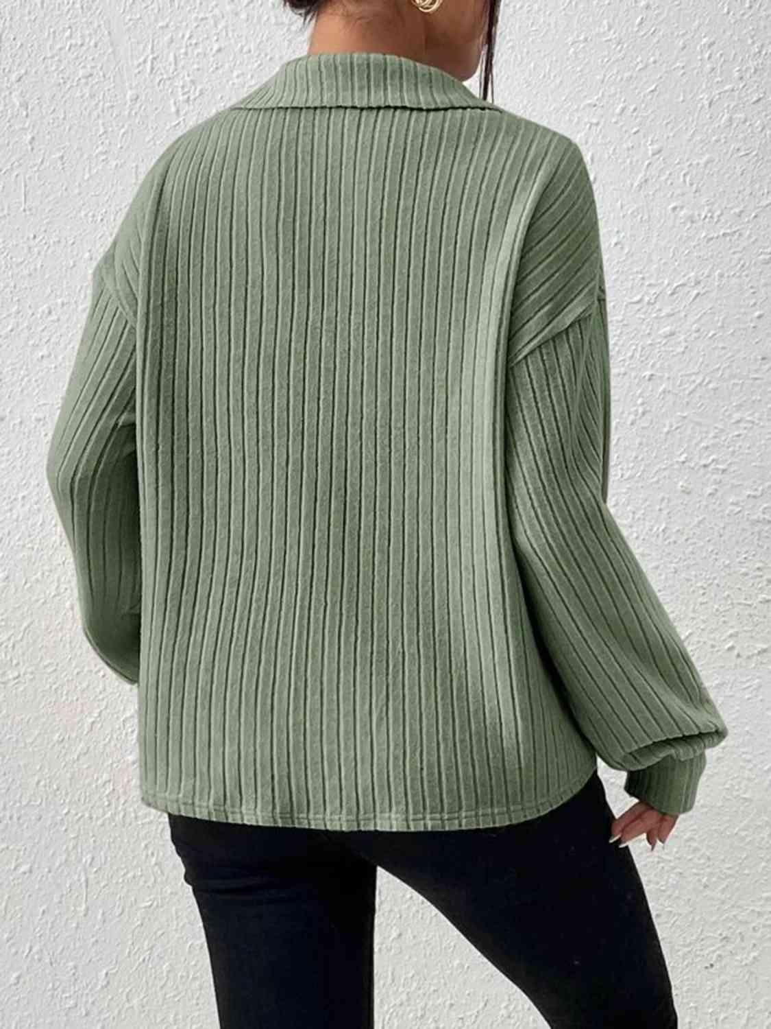 a woman wearing a green sweater and black pants