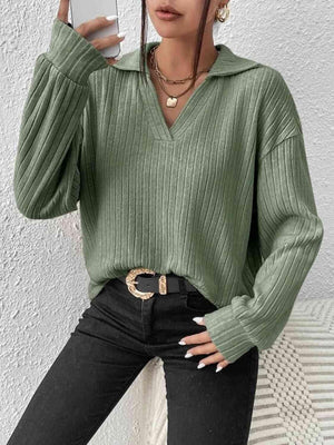 a woman in a green sweater holding a cell phone