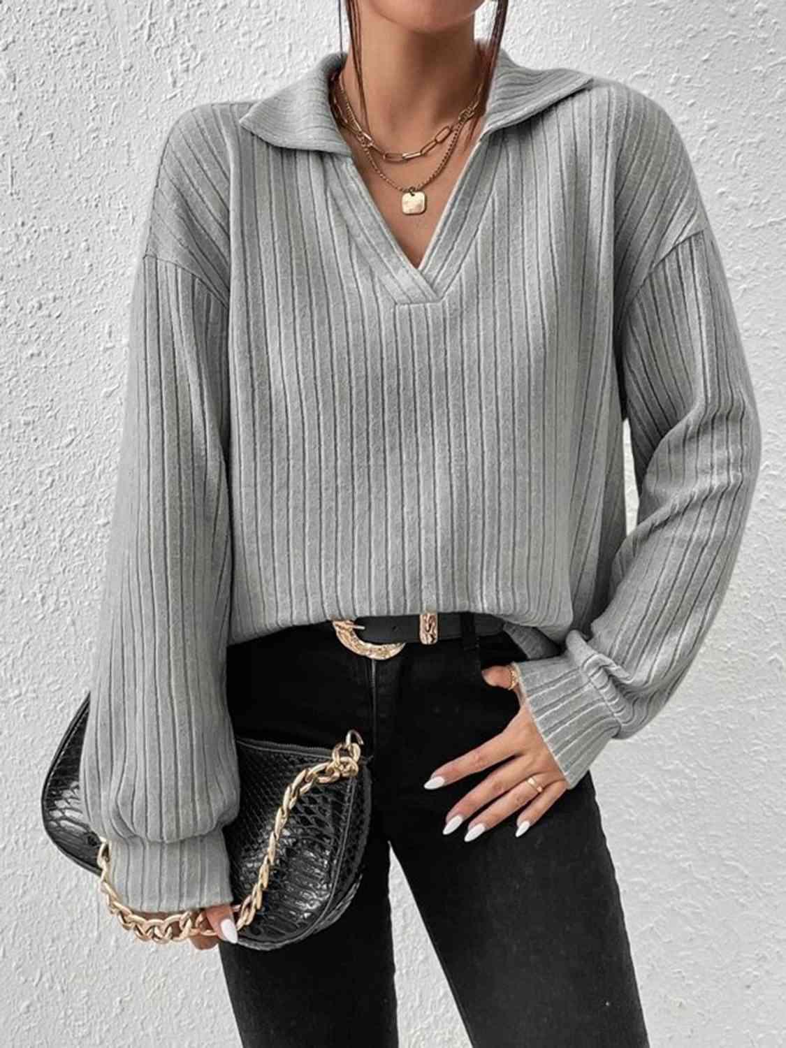 a woman wearing a grey sweater and black jeans