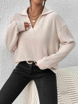 a woman wearing a white sweater and black jeans