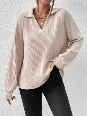 a woman wearing a white sweater and black pants