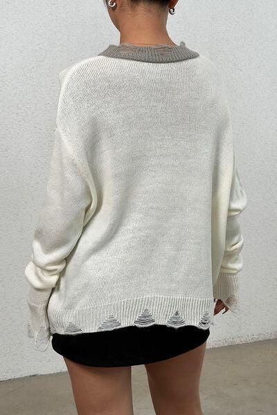 a woman wearing a white sweater and black shorts
