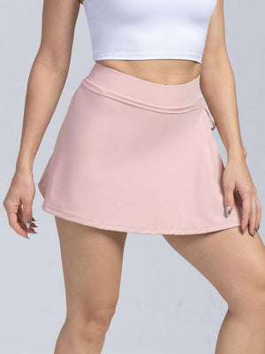 a woman in a white top and pink skirt