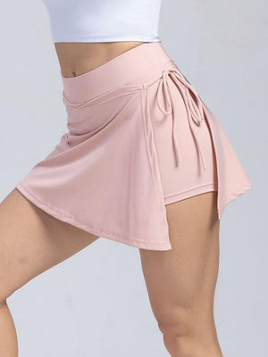 a woman in a white top and a pink skirt