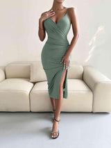 a woman in a green dress standing in front of a couch