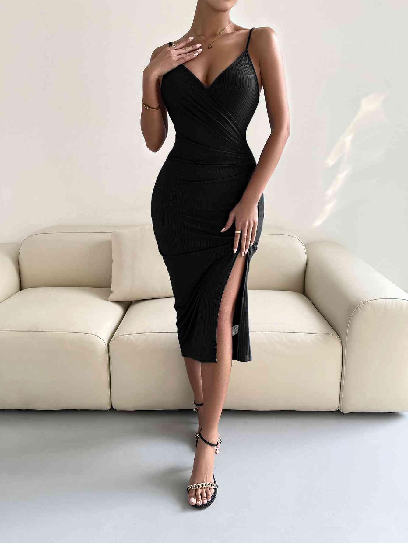 a woman in a black dress standing in front of a couch