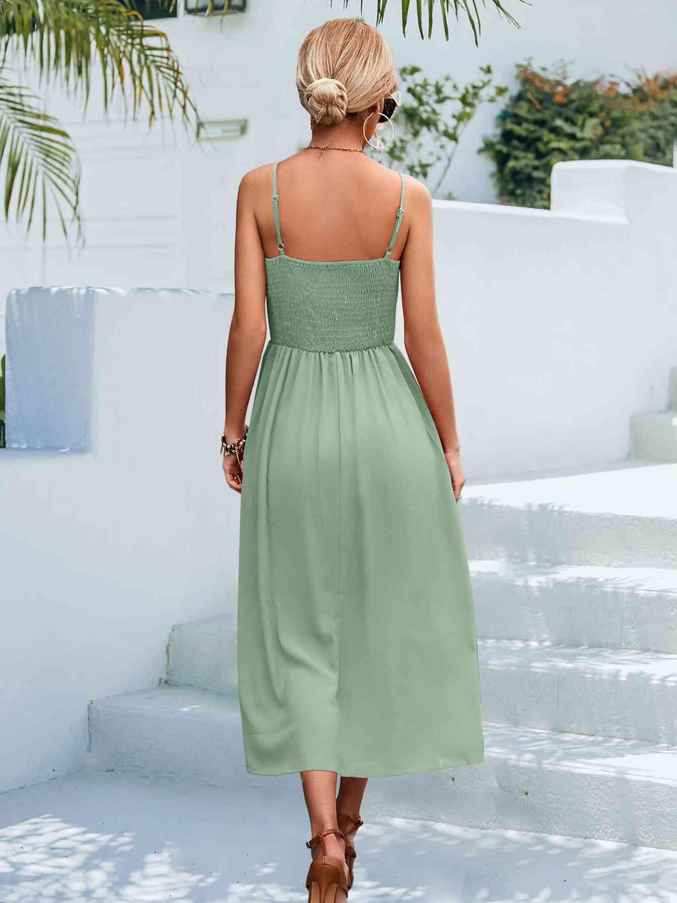 a woman in a green dress walking down some steps
