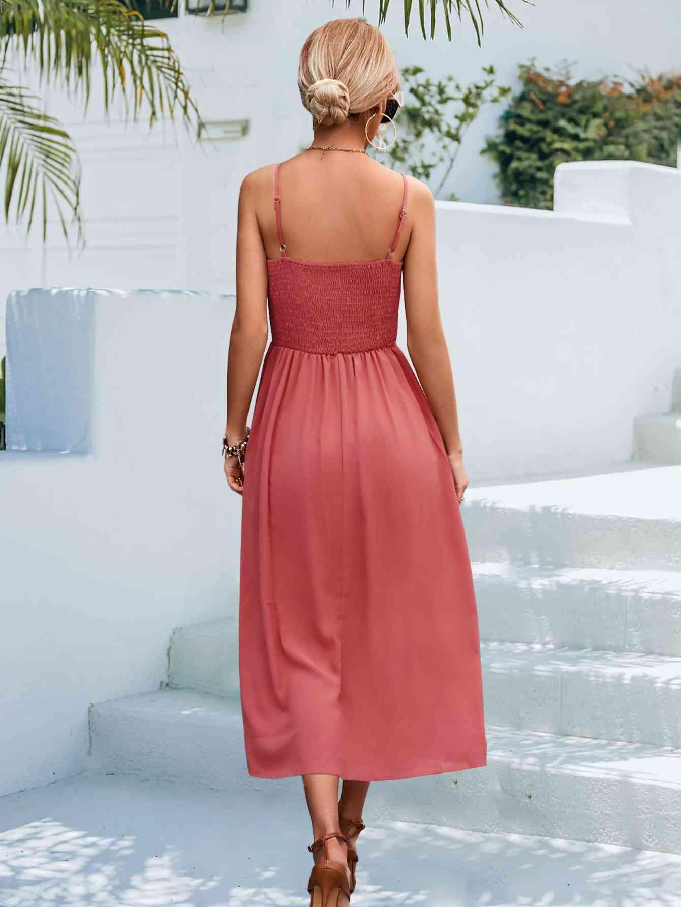 a woman in a pink dress walking down some steps