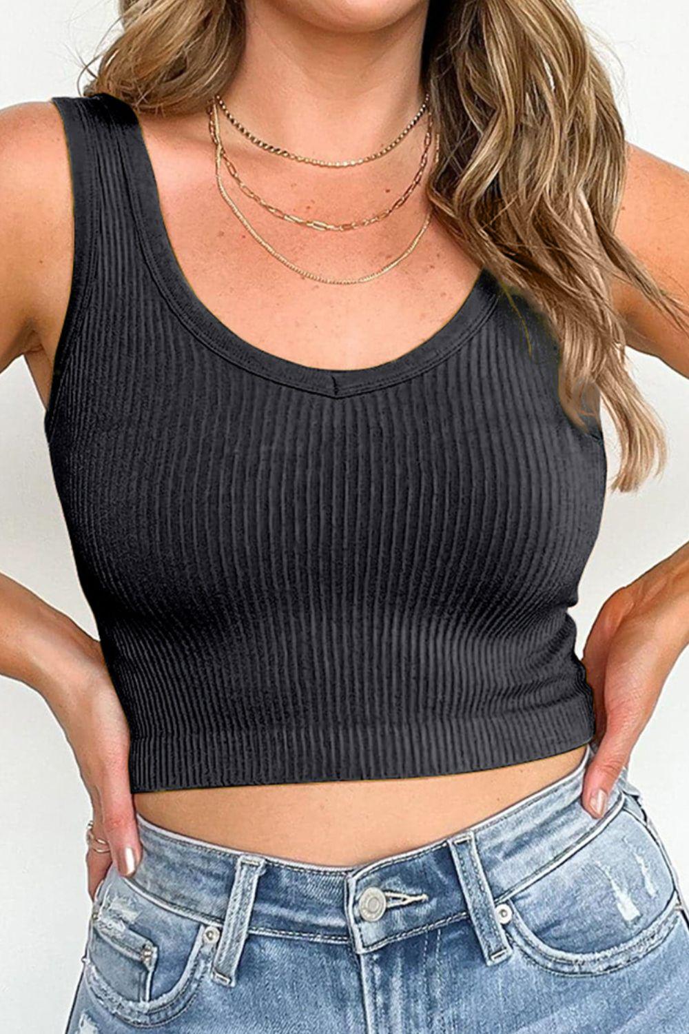 a woman wearing a black tank top and jeans