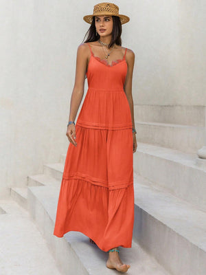 a woman in a long orange dress and straw hat