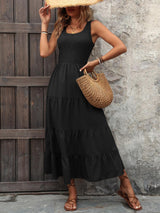 a woman in a black dress and straw hat