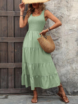 a woman in a green dress and straw hat