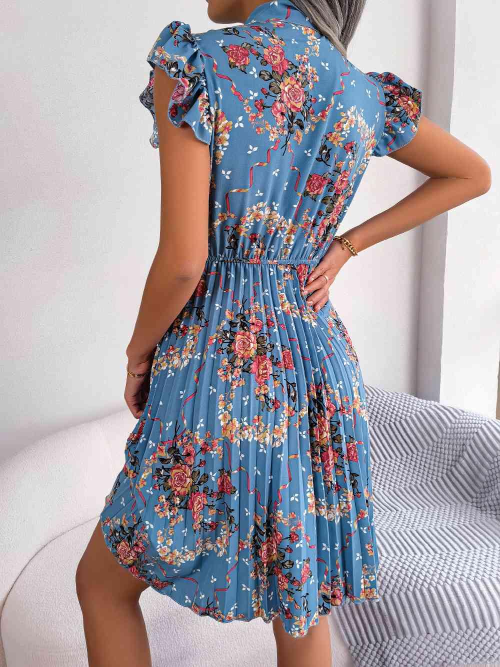 a woman in a blue floral print dress