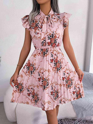 a woman wearing a pink dress with flowers on it