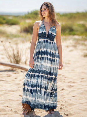 a woman standing in the sand wearing a dress