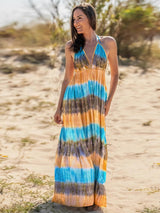 a woman in a long dress standing on a beach